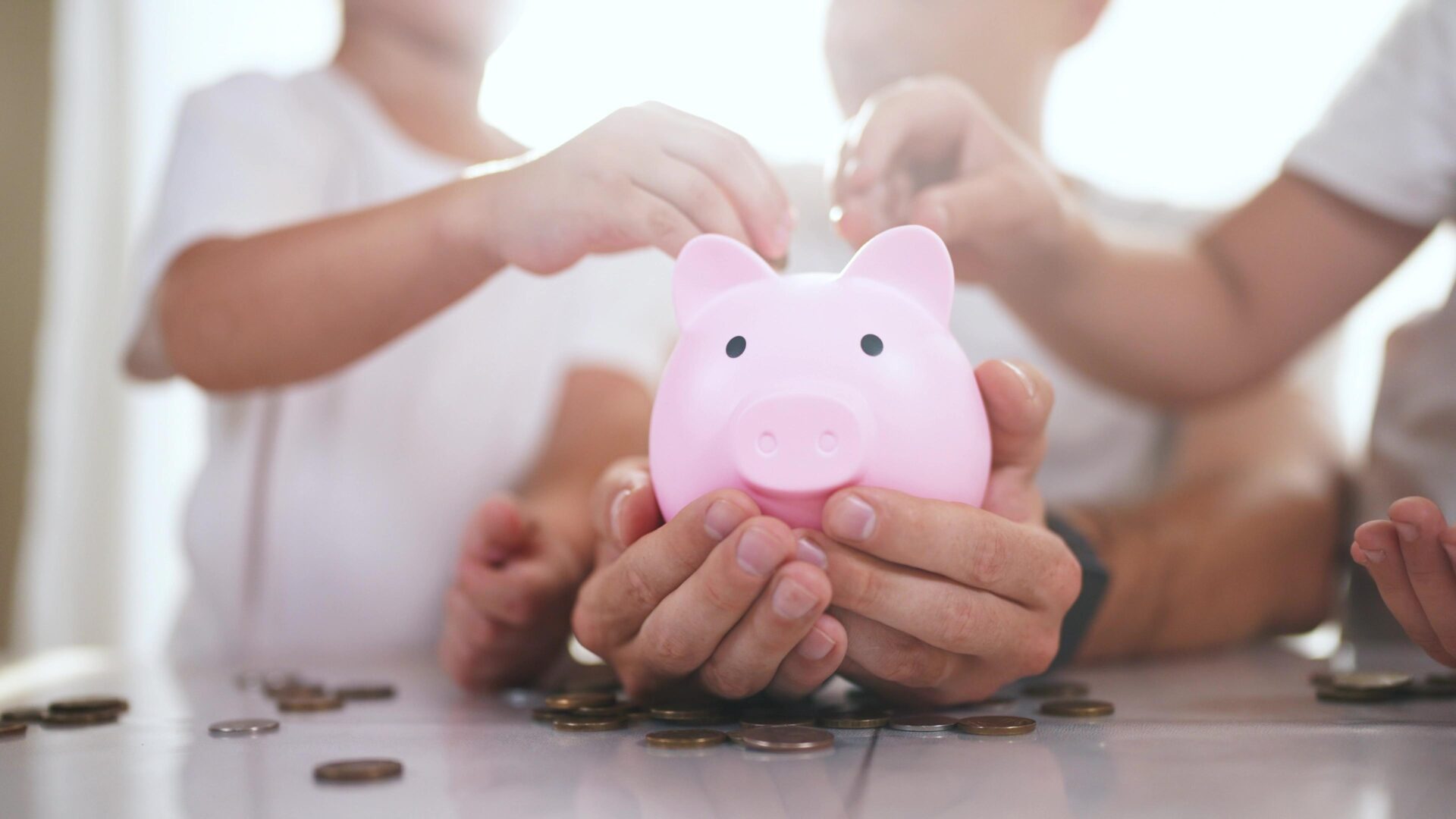 familywithchildrenintheirhandsisholdingapiggy